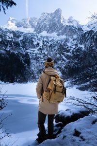 Woman looking out over frozen lake and Dachstein mountain during winter