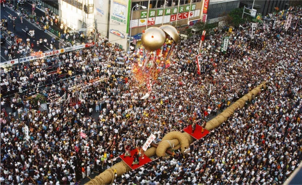 Aerial image of the annual tug-of-war festival in Naha, Okinawa, featuring a crowd of people and a massive rope
