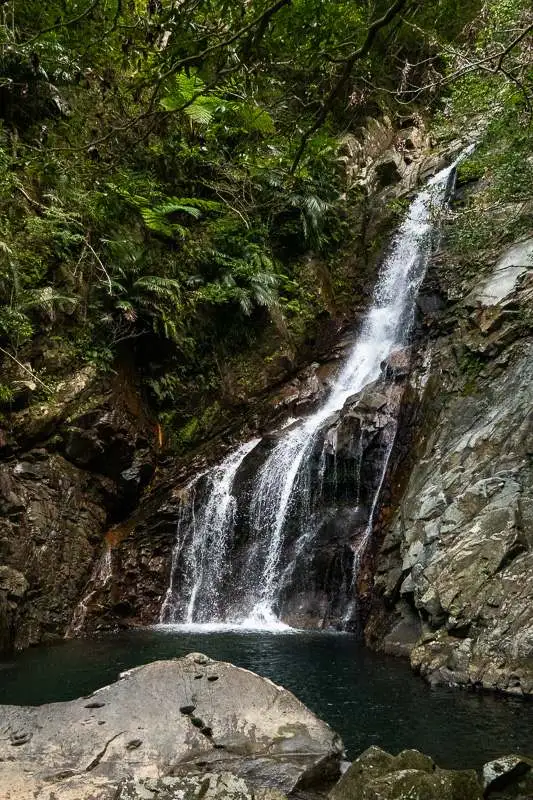 A waterfall cascading through the jungle at Hijio Falls in Okinawa