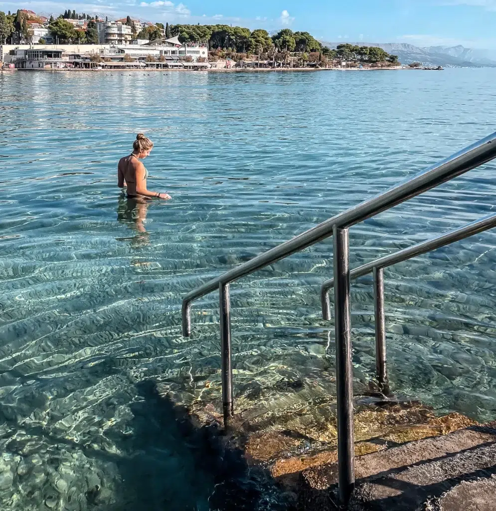 Woman swimming in the blue water at Bacvice Beach in Split, Croatia