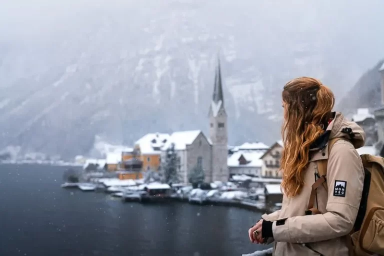 Woman standing looking out over a snow covered Halstatt