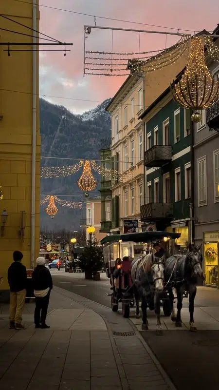 A horse drawn carriage walking down the streets of Bad Ischl during Christmas