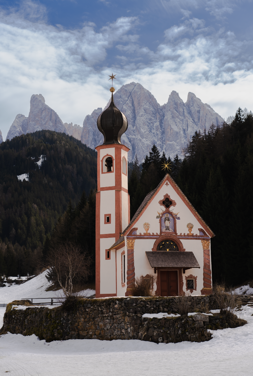 Church of St. John in the Dolomites with the mountains in the background