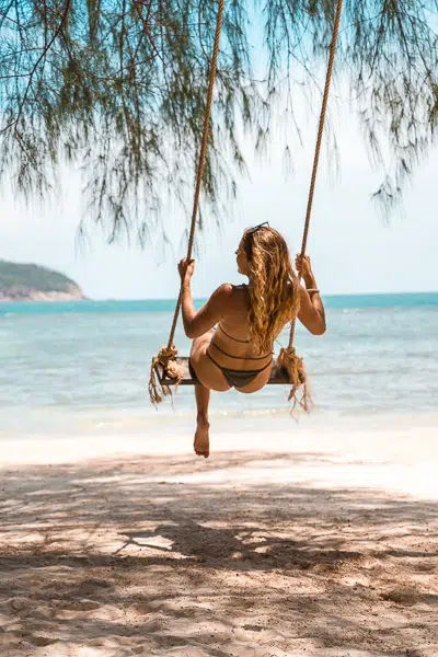 Girl swinging on a beach in Thailand