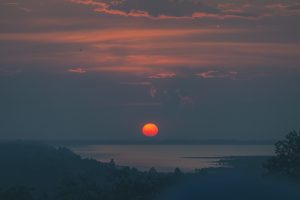 Glowing sun setting over an inland lake in Cambodia
